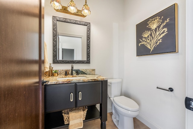 bathroom featuring wood-type flooring, vanity, and toilet