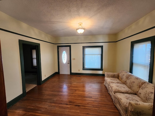 foyer entrance featuring a textured ceiling and dark hardwood / wood-style floors