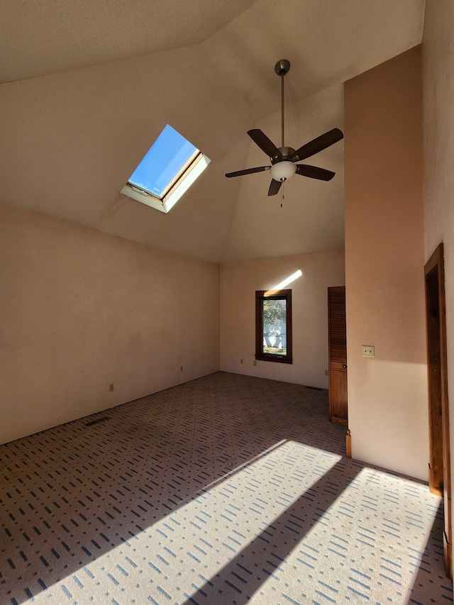 interior space with ceiling fan, dark carpet, and vaulted ceiling