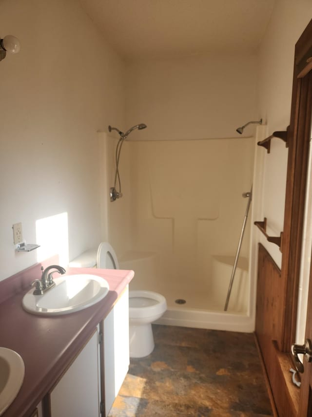 bathroom featuring vanity, toilet, and walk in shower