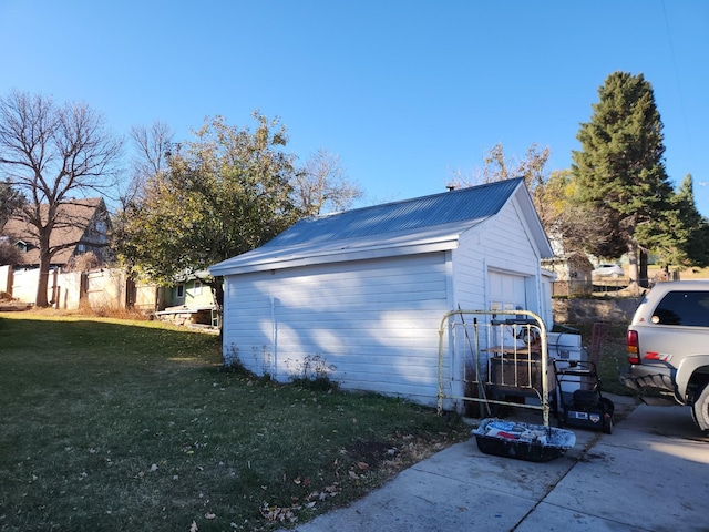 view of property exterior with a lawn, an outdoor structure, and a garage