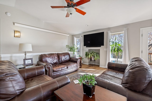 living room with hardwood / wood-style flooring, ceiling fan, and lofted ceiling