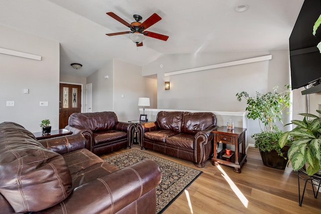 living room featuring ceiling fan, light hardwood / wood-style floors, and lofted ceiling