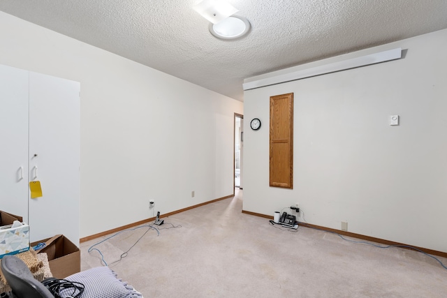 carpeted spare room featuring a textured ceiling