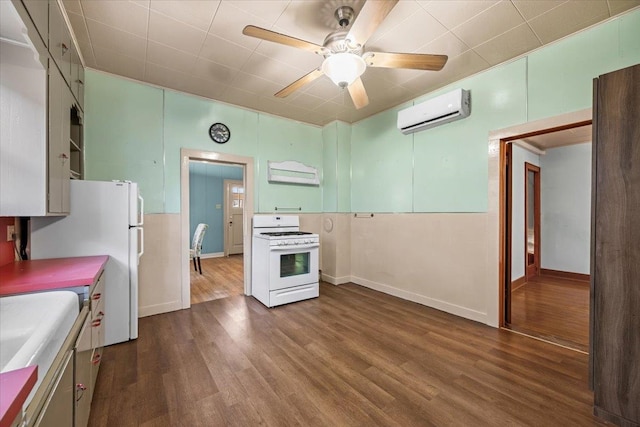 kitchen with ceiling fan, dark hardwood / wood-style flooring, white appliances, and a wall mounted AC