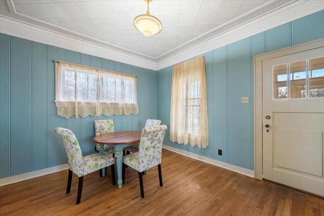 dining area with hardwood / wood-style floors and crown molding