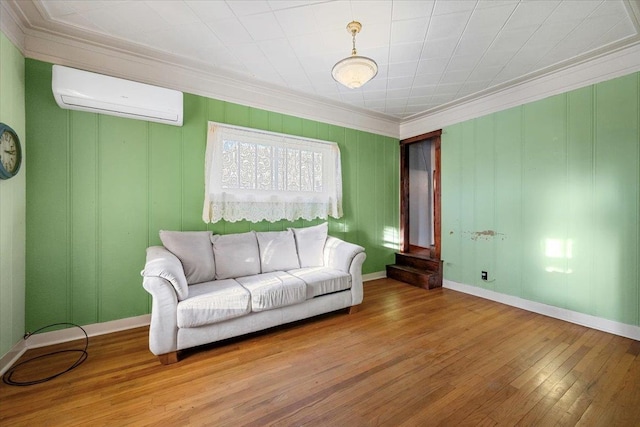 living room featuring hardwood / wood-style flooring, an AC wall unit, and ornamental molding