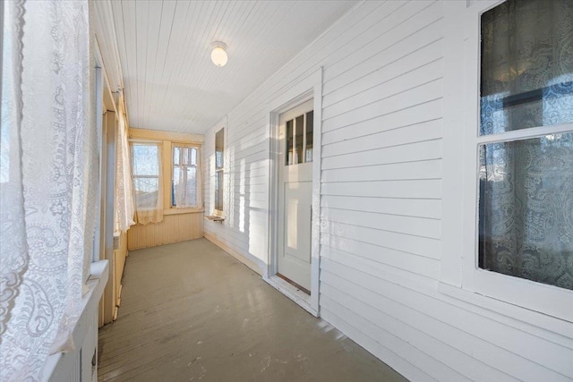 hall with wood walls and concrete floors