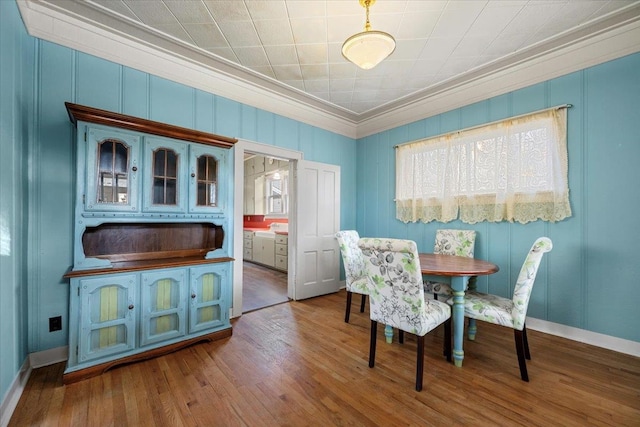 dining room with wood-type flooring and crown molding