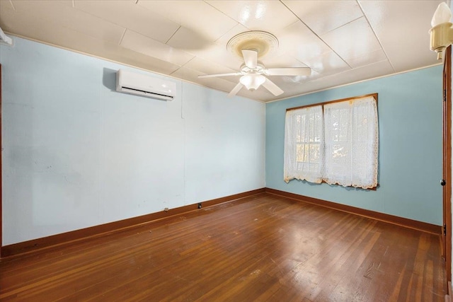 spare room with hardwood / wood-style floors, an AC wall unit, and ceiling fan