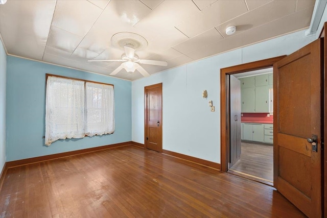 empty room with ceiling fan and dark wood-type flooring