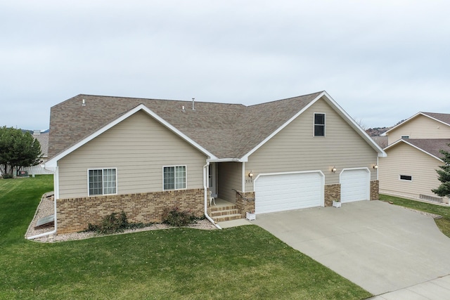view of front facade with a front yard, roof with shingles, brick siding, concrete driveway, and an attached garage