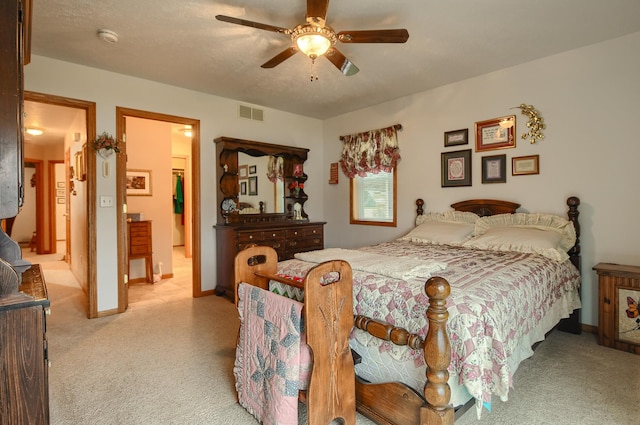 bedroom featuring connected bathroom, ceiling fan, and light colored carpet