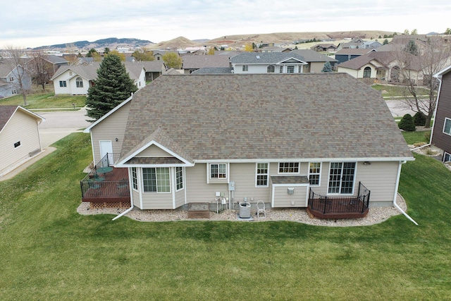 back of property with central air condition unit, a mountain view, and a yard