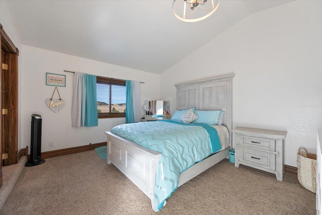 carpeted bedroom with an inviting chandelier and vaulted ceiling