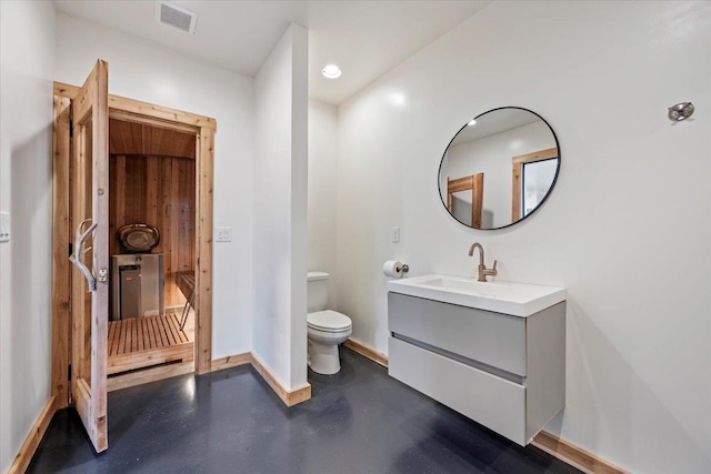 bathroom featuring concrete flooring, vanity, and toilet