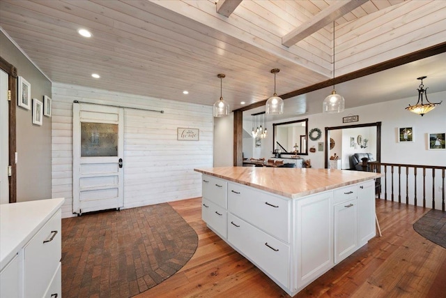 kitchen featuring white cabinets, pendant lighting, a kitchen island, and wood ceiling