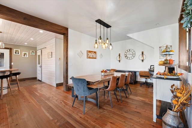 dining space with hardwood / wood-style floors and beamed ceiling