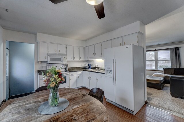 kitchen featuring white cabinets, white appliances, dark hardwood / wood-style floors, and sink