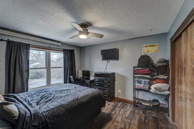 bedroom featuring a textured ceiling, ceiling fan, and dark wood-type flooring