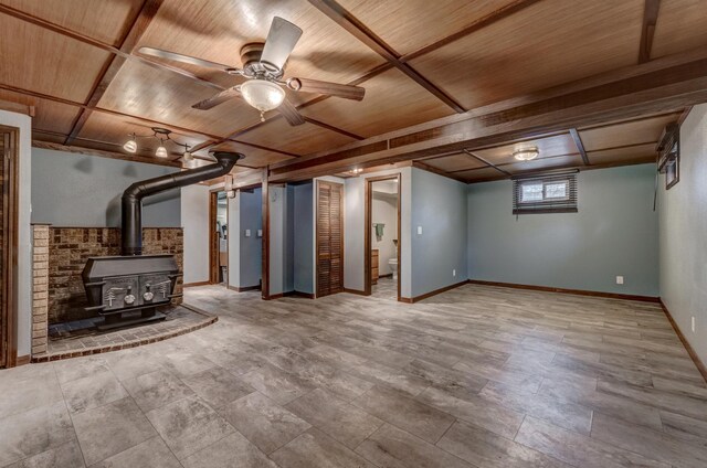 basement featuring a wood stove, ceiling fan, and wood ceiling