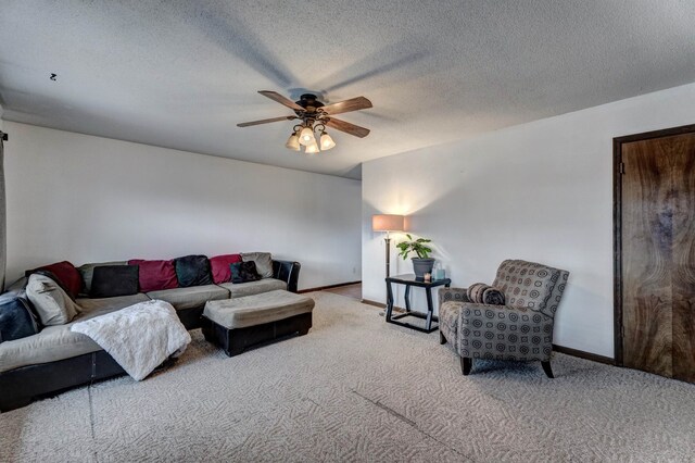 living room with a textured ceiling, light colored carpet, and ceiling fan