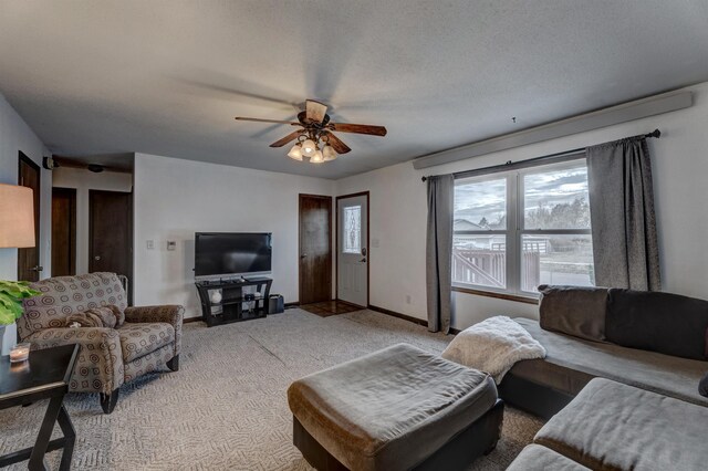 living room with light carpet, ceiling fan, and a textured ceiling