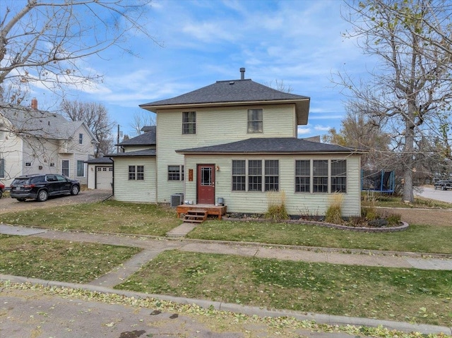 view of front property featuring a trampoline, a front yard, and central air condition unit