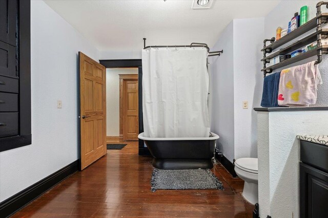 full bathroom with hardwood / wood-style floors, shower / bath combo, toilet, and vanity