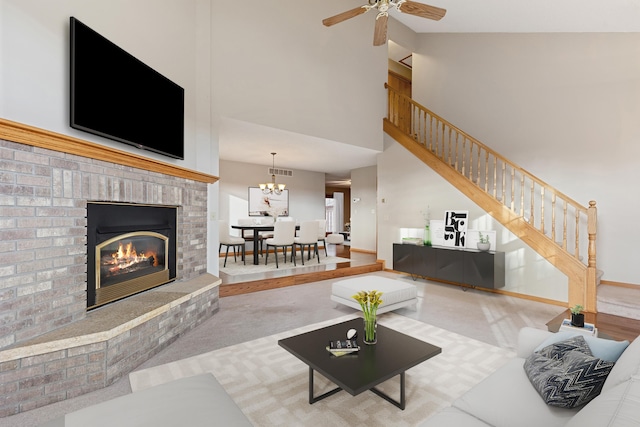 carpeted living room featuring high vaulted ceiling, ceiling fan with notable chandelier, and a brick fireplace