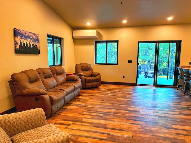 living room with vaulted ceiling, a wealth of natural light, hardwood / wood-style floors, and a wall mounted air conditioner