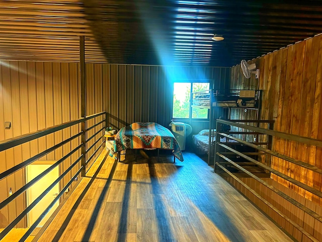 bedroom with hardwood / wood-style flooring and wood walls