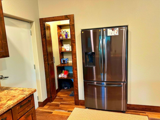 kitchen featuring stainless steel fridge and light hardwood / wood-style flooring