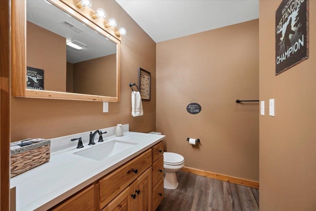 bathroom with vanity, hardwood / wood-style flooring, and toilet