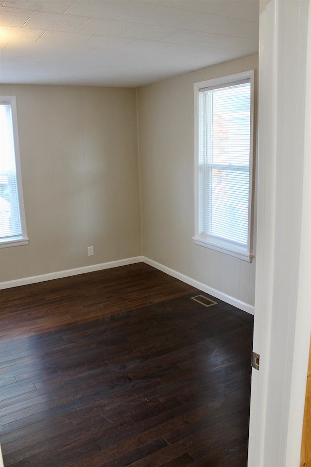 empty room with dark hardwood / wood-style flooring