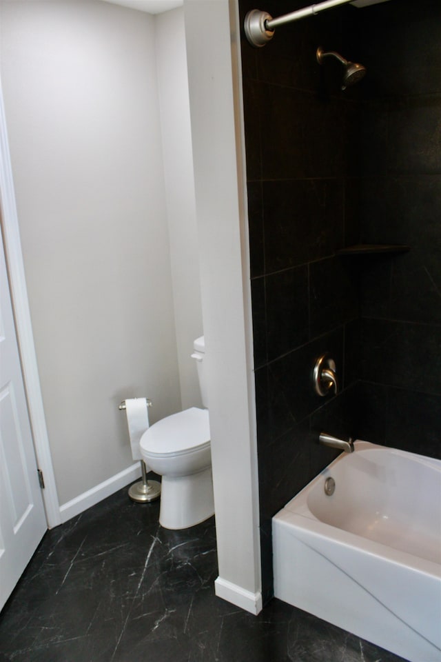 bathroom with toilet and tiled shower / bath