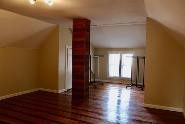 additional living space featuring dark wood-type flooring and lofted ceiling