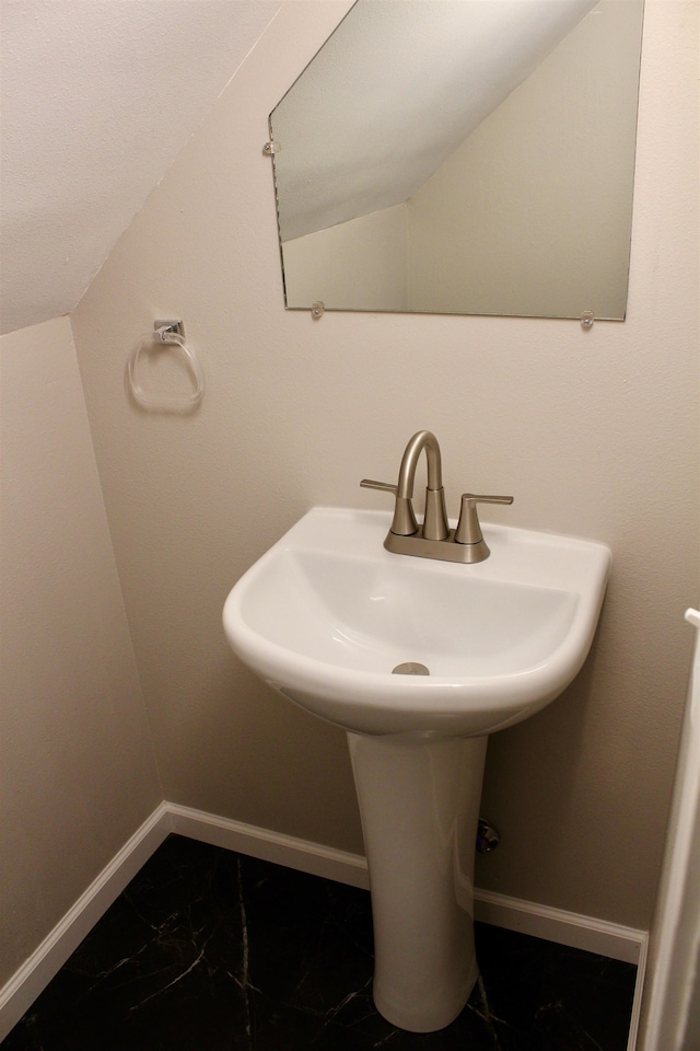 bathroom featuring sink and vaulted ceiling