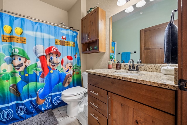 bathroom featuring tile patterned floors, vanity, and toilet