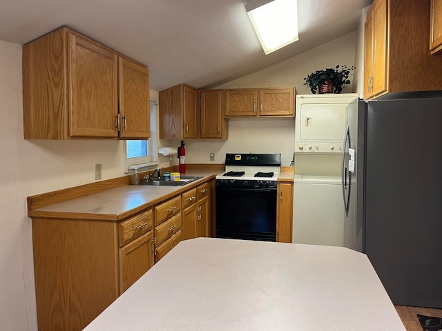 kitchen featuring stove, black refrigerator with ice dispenser, stacked washer and clothes dryer, sink, and vaulted ceiling