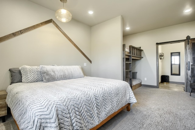 carpeted bedroom featuring a barn door