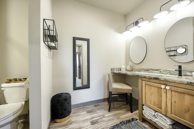 bathroom with hardwood / wood-style flooring, vanity, and toilet