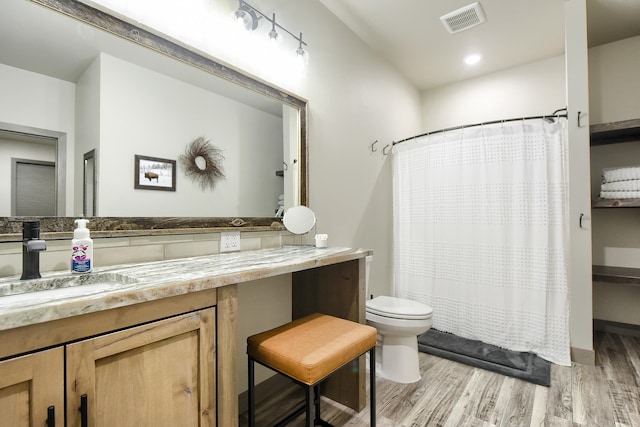 bathroom with vanity, hardwood / wood-style flooring, toilet, and walk in shower