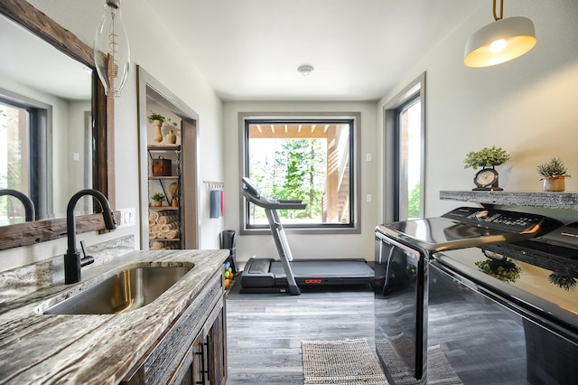 interior space featuring washer and clothes dryer, wood-type flooring, and sink