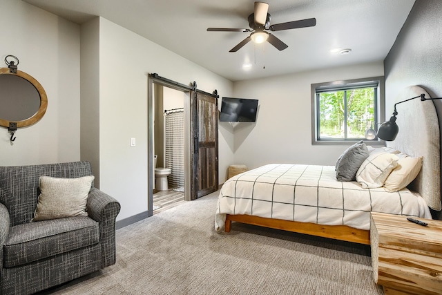 carpeted bedroom featuring ceiling fan, a barn door, and ensuite bathroom