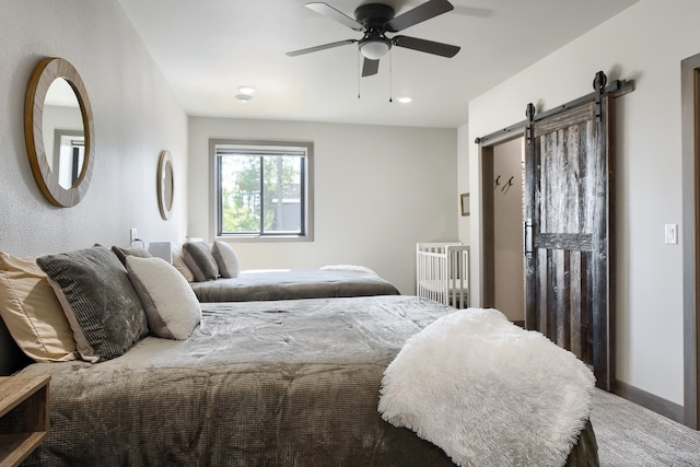 bedroom featuring a barn door and ceiling fan