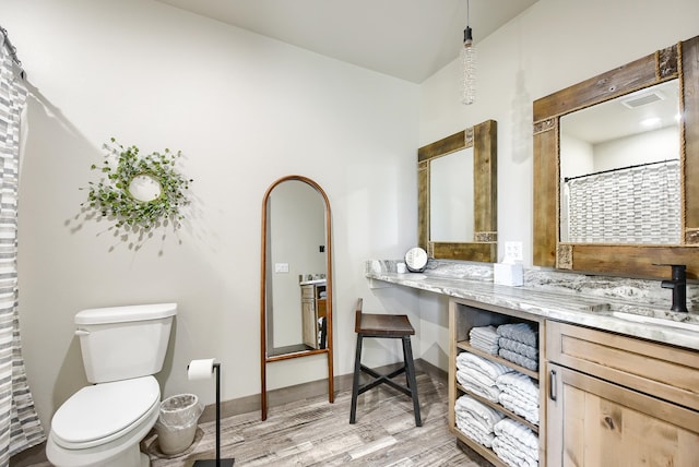 bathroom featuring vanity, hardwood / wood-style flooring, and toilet