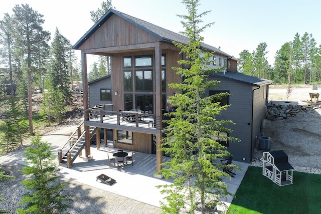 rear view of property featuring a deck and a patio