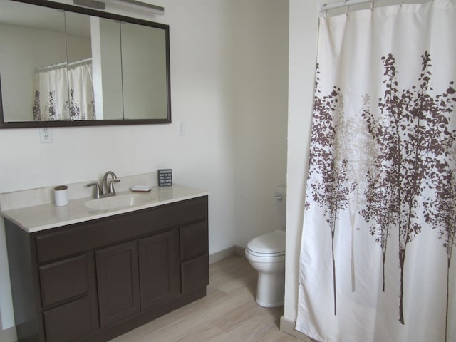 bathroom with vanity, hardwood / wood-style flooring, and toilet