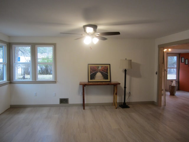 unfurnished room with ceiling fan, a healthy amount of sunlight, and wood-type flooring